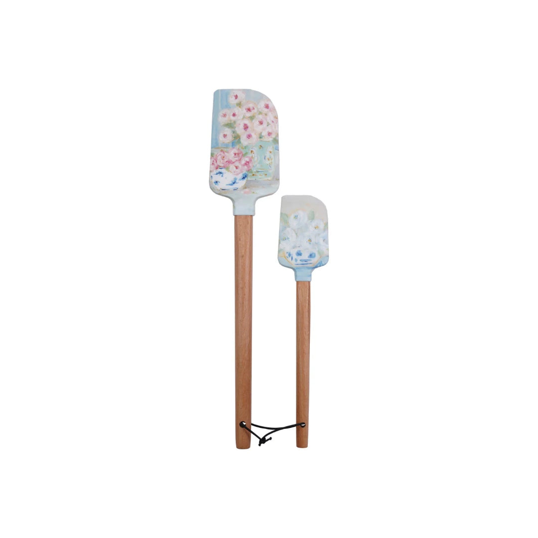 Two floral-patterned spatulas with wooden handles on a white background