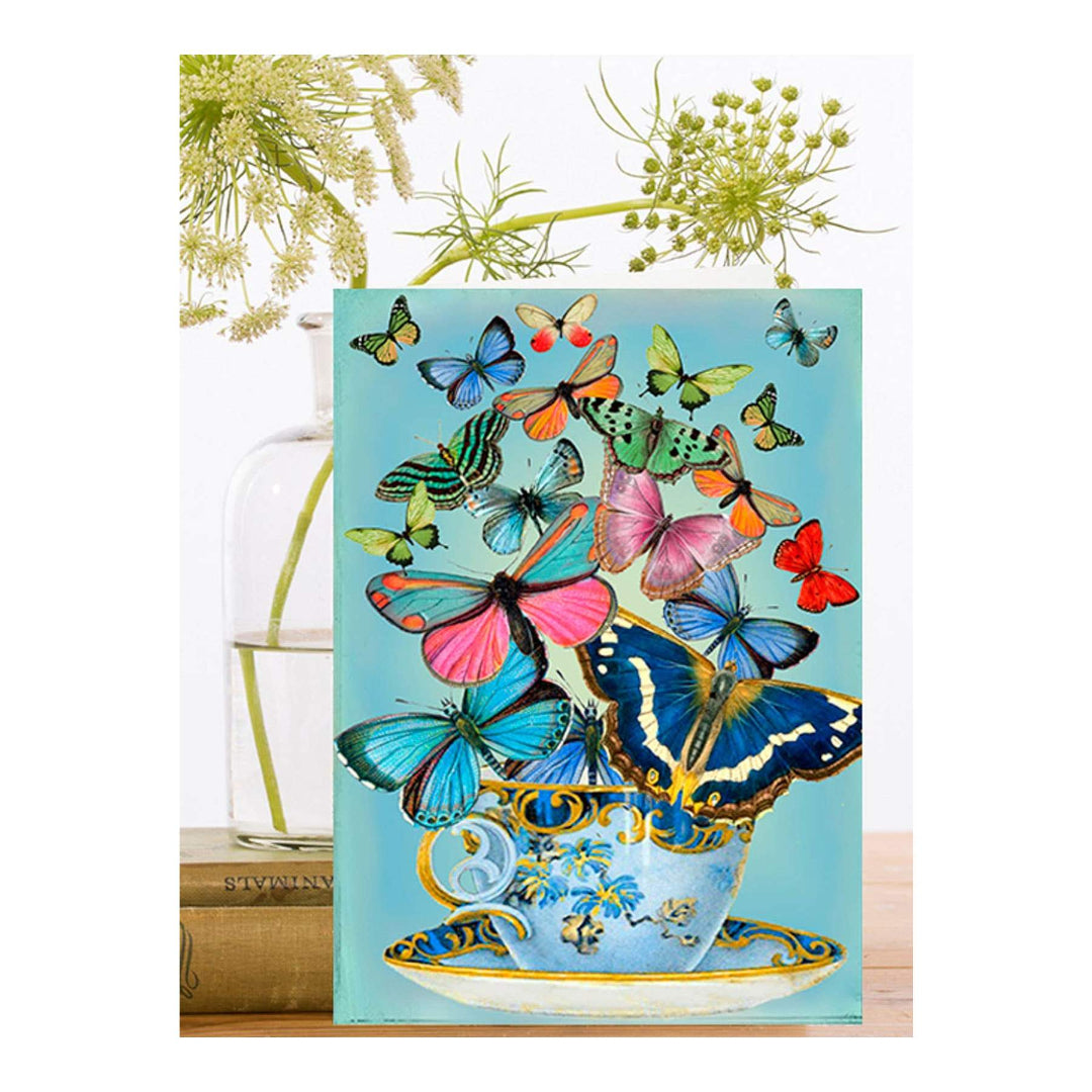 Carte de vœux vierge avec papillons et tasse de thé