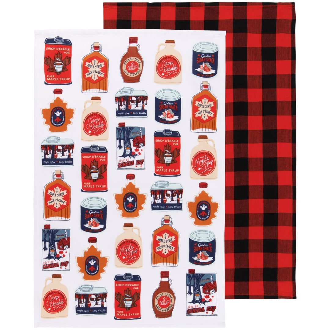A white tea towel featuring a collage of holiday syrup and can labels, shown next to a red and black plaid tea towel.