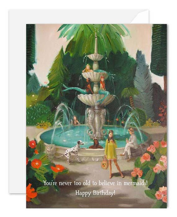 A greeting card featuring an illustration of a mermaid fountain with people around it, including a birthday cake with the text 'You're never too old to believe in mermaids! Happy Birthday'.