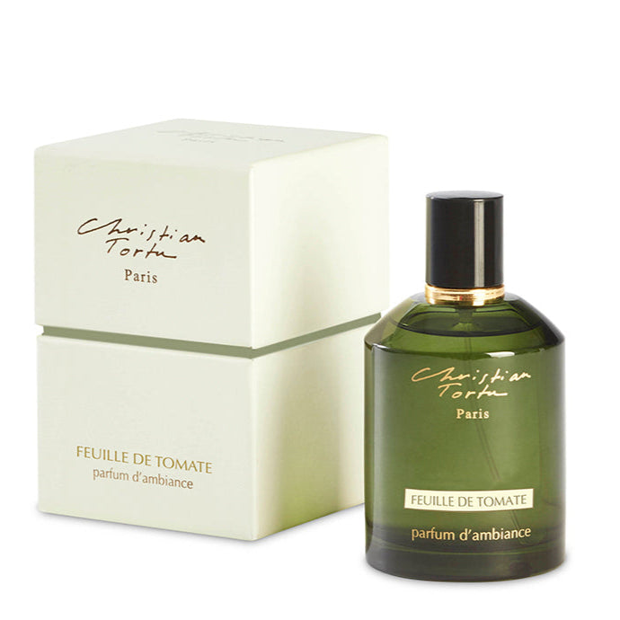 A Christian Tortu Tomato Leaf room spray in a green bottle with a gold cap, next to its white packaging box with the brand and product name displayed.