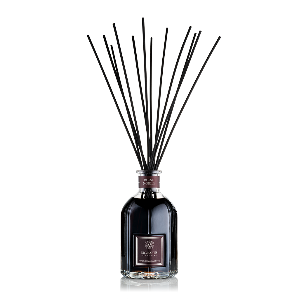 A fragrance diffuser with a clear bottle and black decorative reeds.