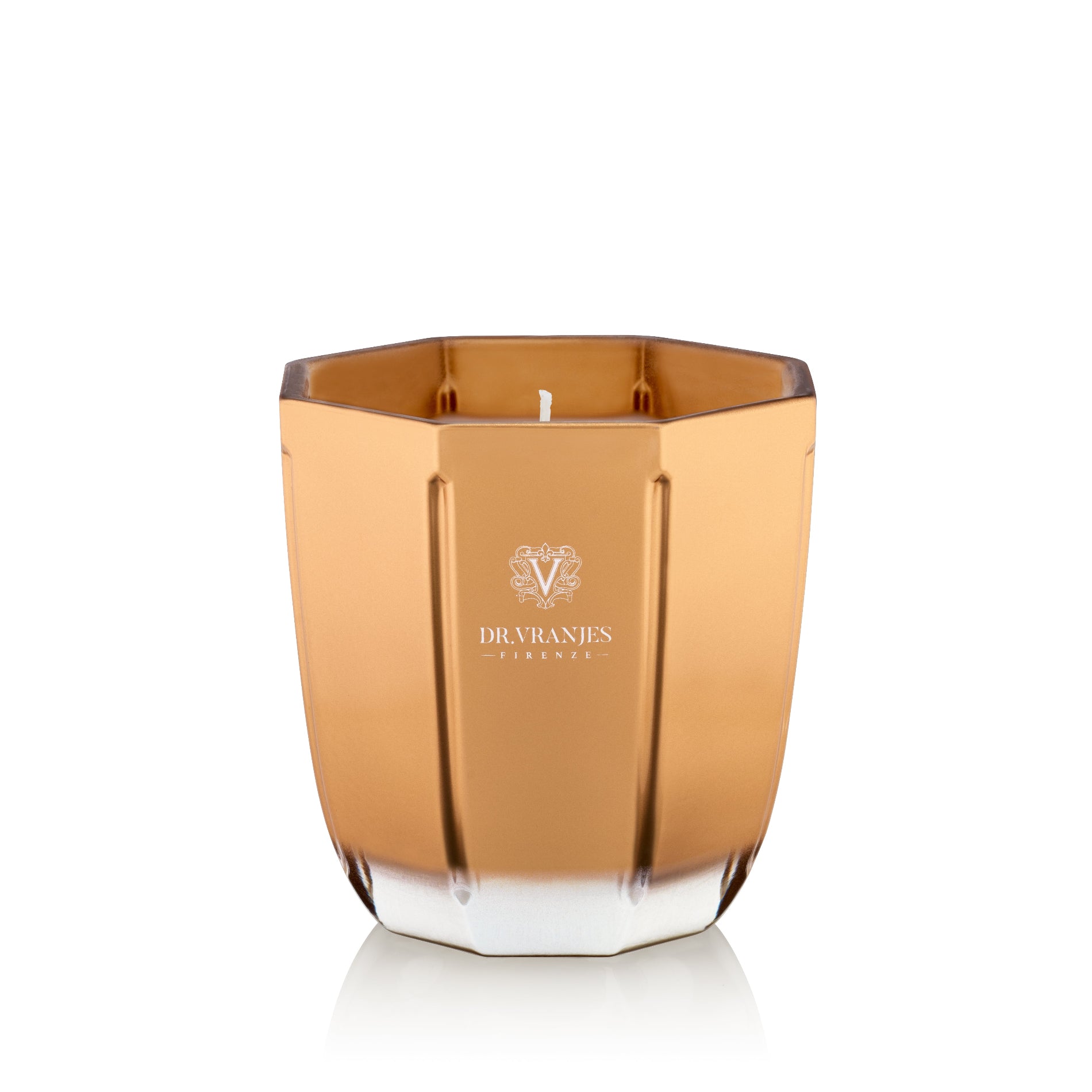 A gold-colored, octagonal scented candle in a glass vessel with a white candle visible from the top