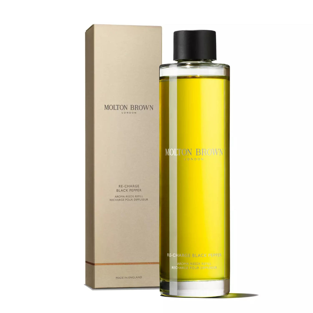 Molton Brown product with yellow liquid and black cap on a white background