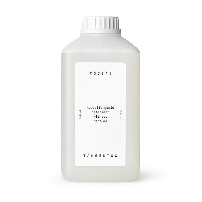 A bottle of Tangent GC hypoallergenic detergent without perfume, in a clear liquid form, with a white label displaying product information.