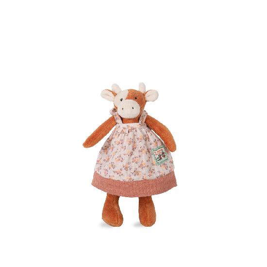 A miniature soft toy resembling a cow with a floral dress standing against a white background.
