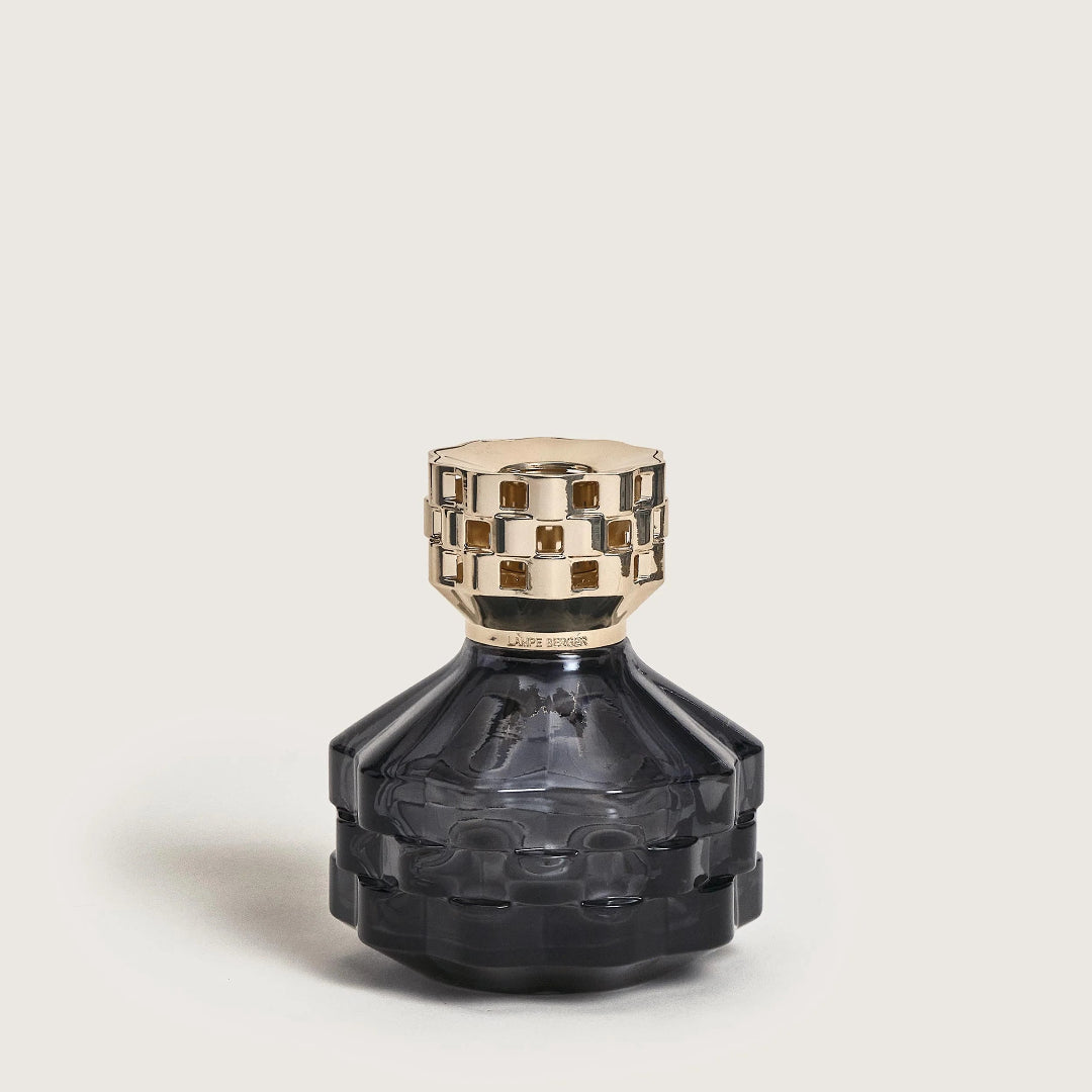 Black perfume bottle with gold cap on a light beige background