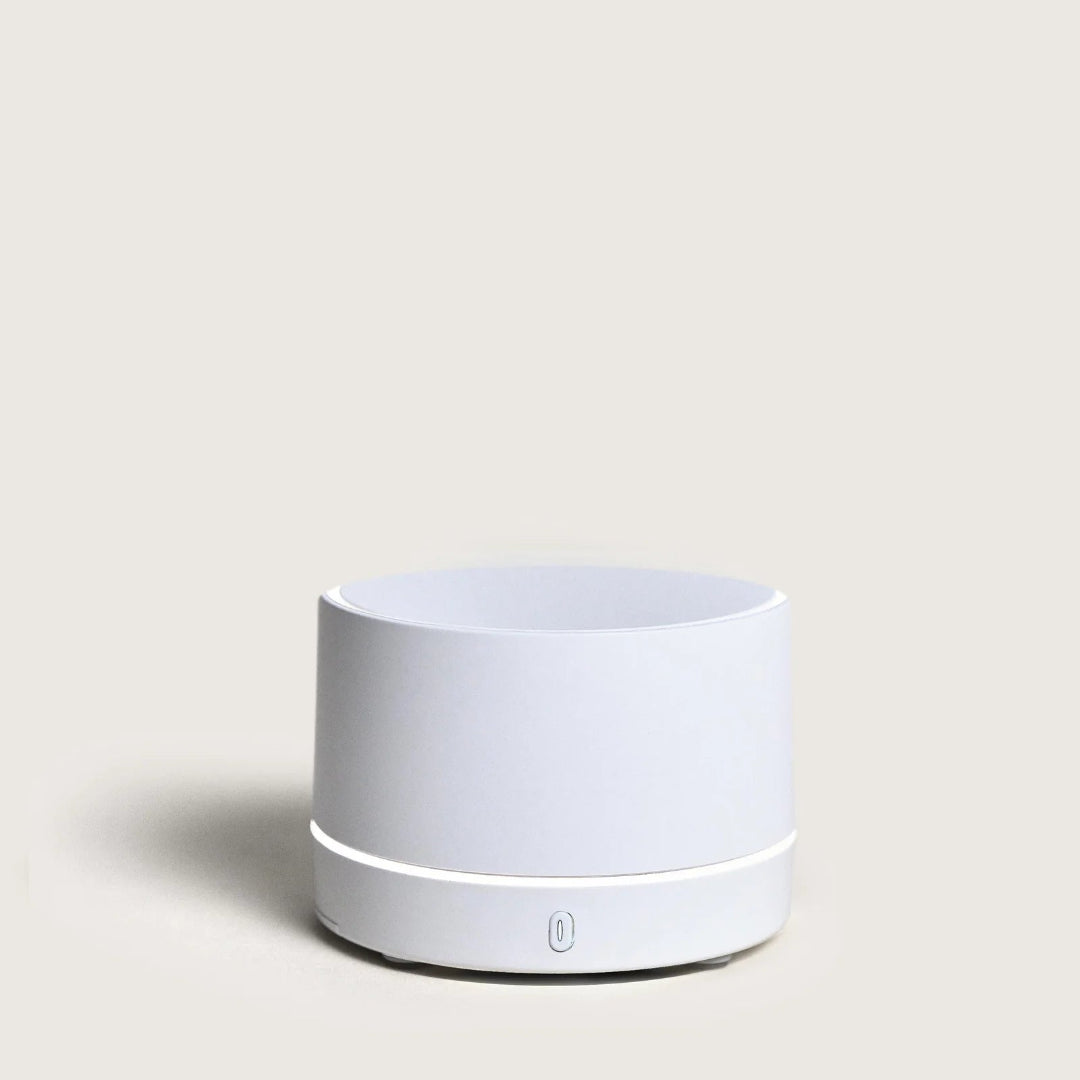 White cylindrical portable diffuser on a light gray background