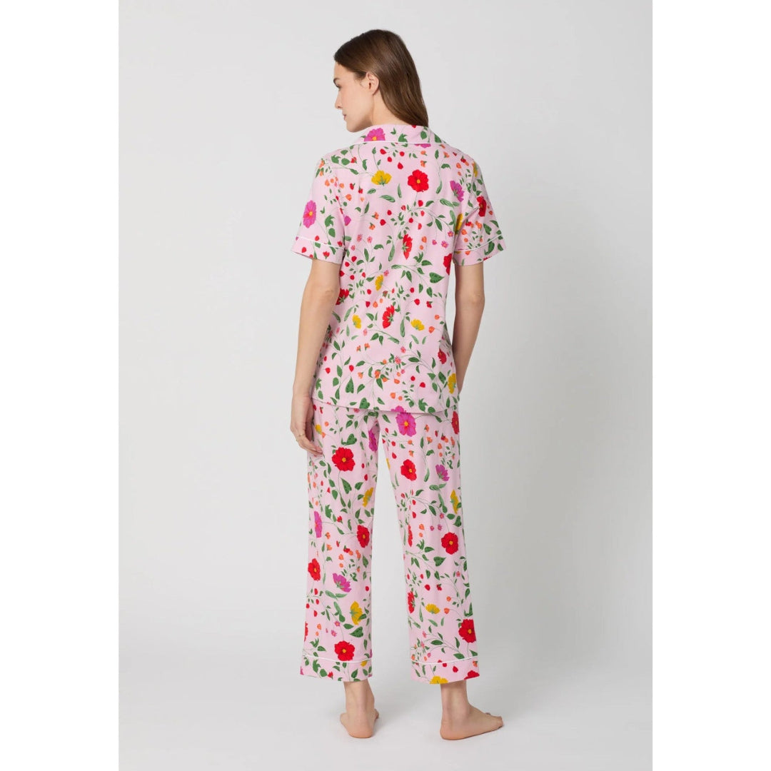 Woman wearing a floral pajama set on a white background