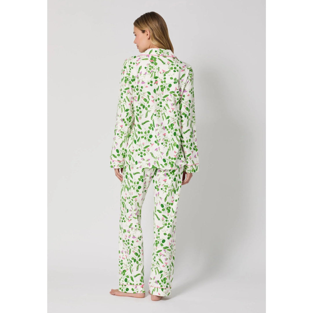 Woman wearing a floral pajama set on a plain background