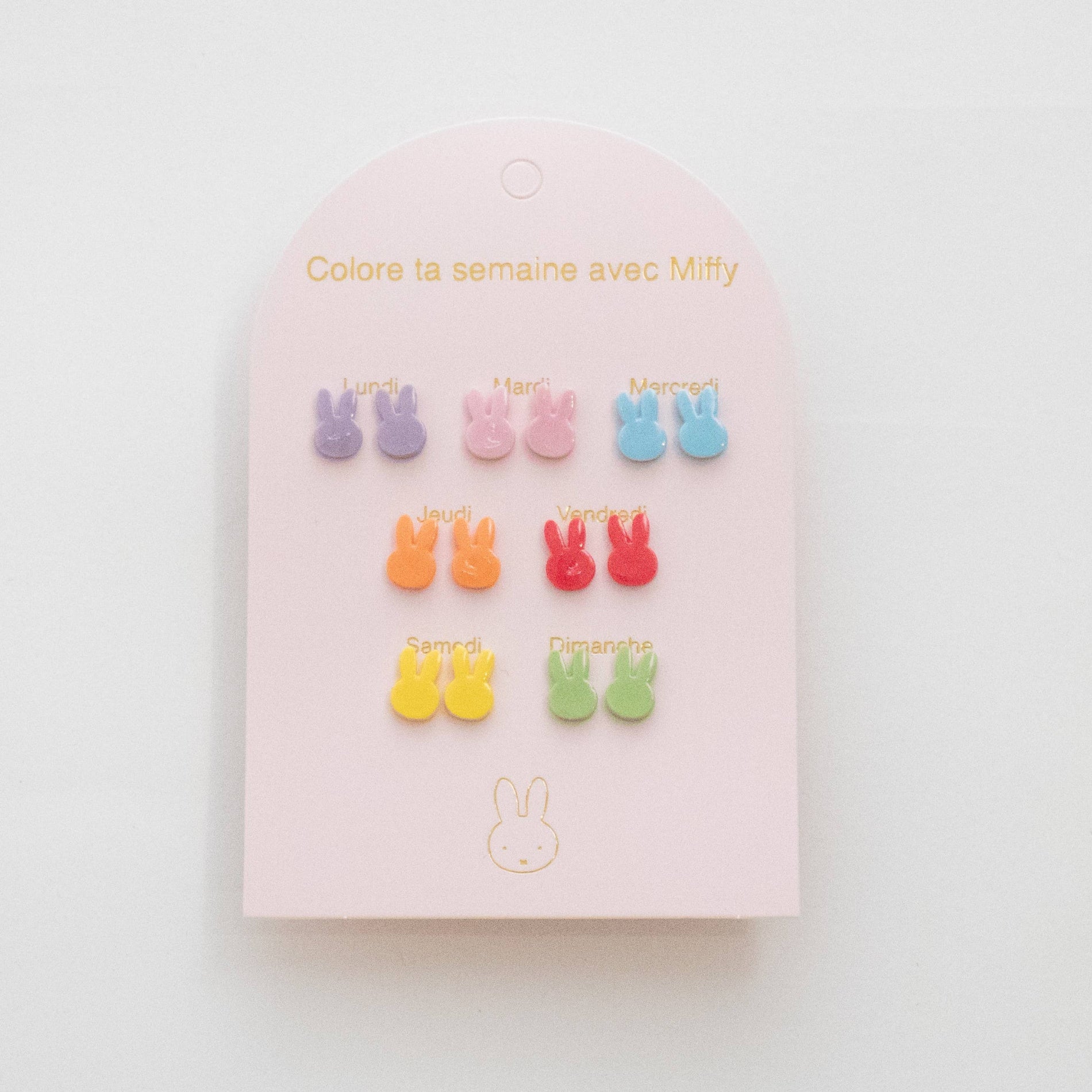 Set of colorful bunny-shaped earrings on a pink card with text