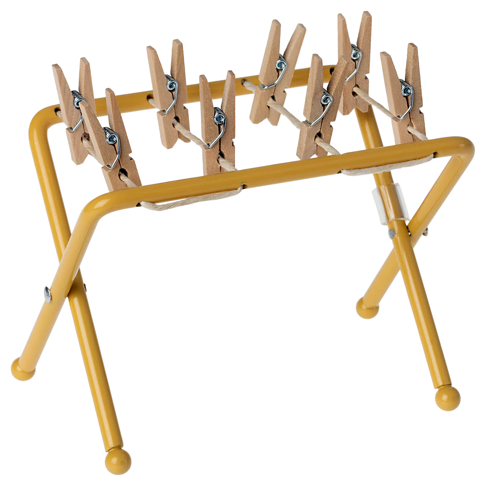 Yellow clothespin rack with wooden pegs on a white background