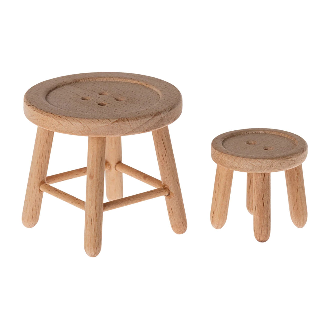 Two wooden stools with round seats on a white background