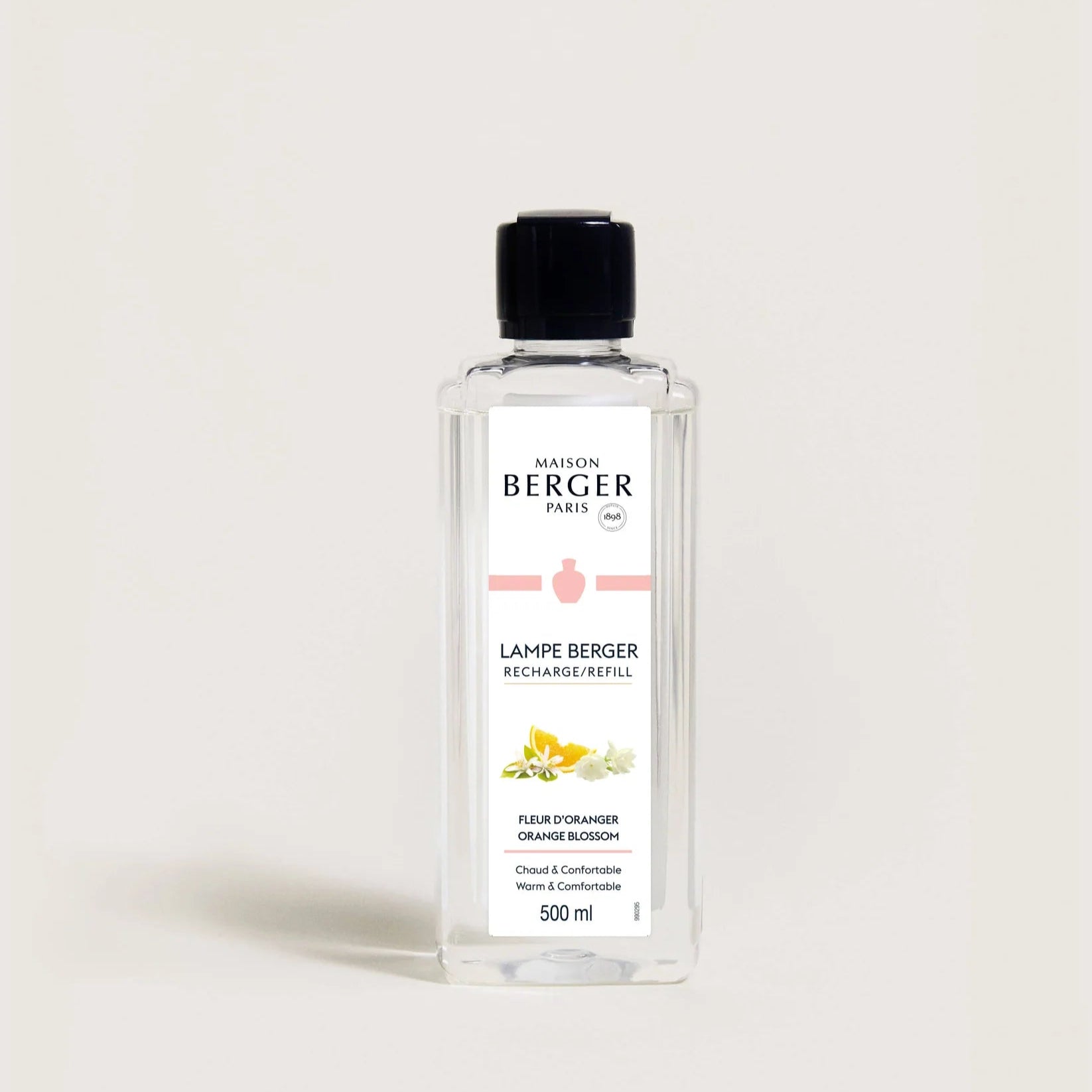 A clear bottle of Maison Berger fragrance diffuser refill with label, predominantly white label with orange and green text and accents.