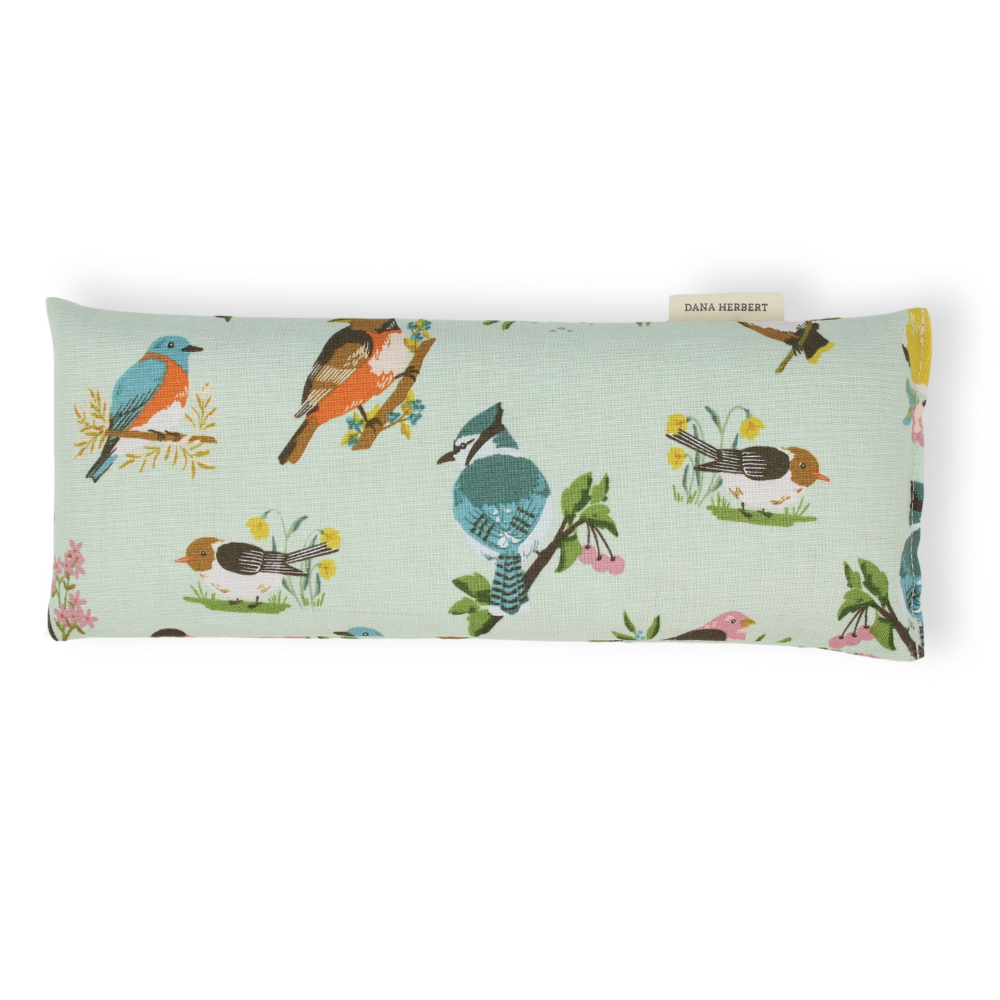 Rectangular pillow with bird pattern on a light green background