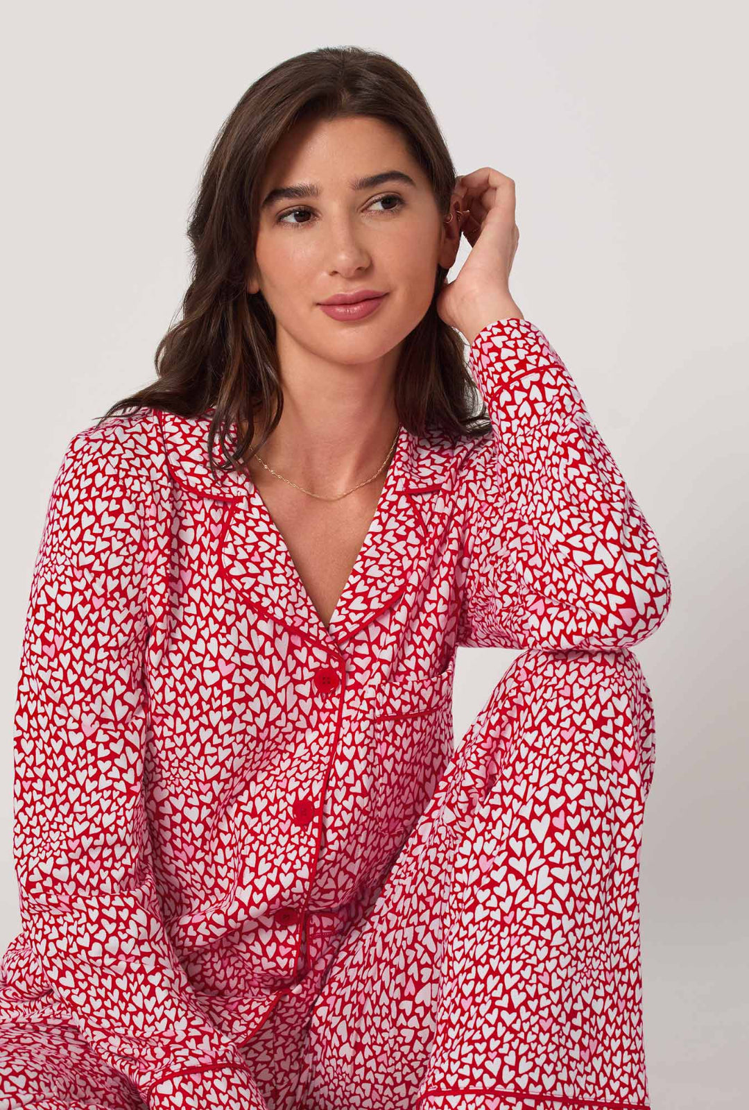 Woman wearing a red and white patterned outfit on a plain background