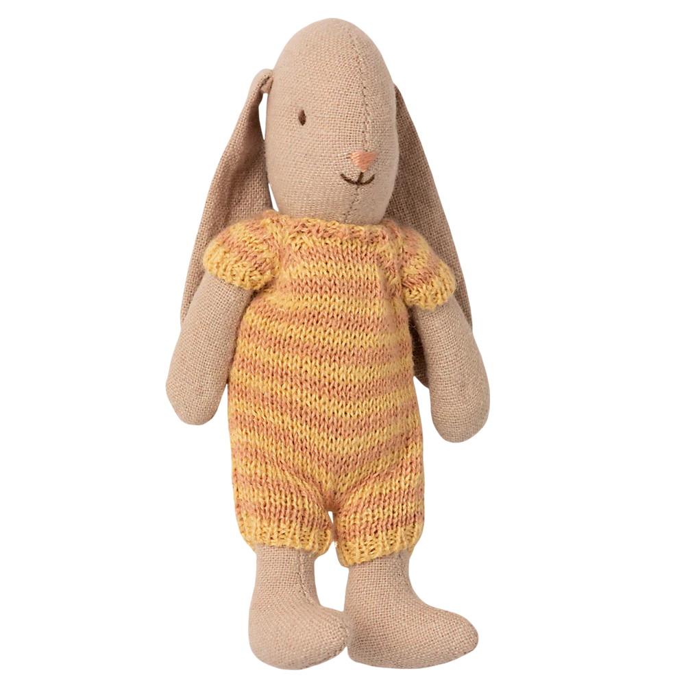 Knitted toy rabbit in a yellow outfit on a white background