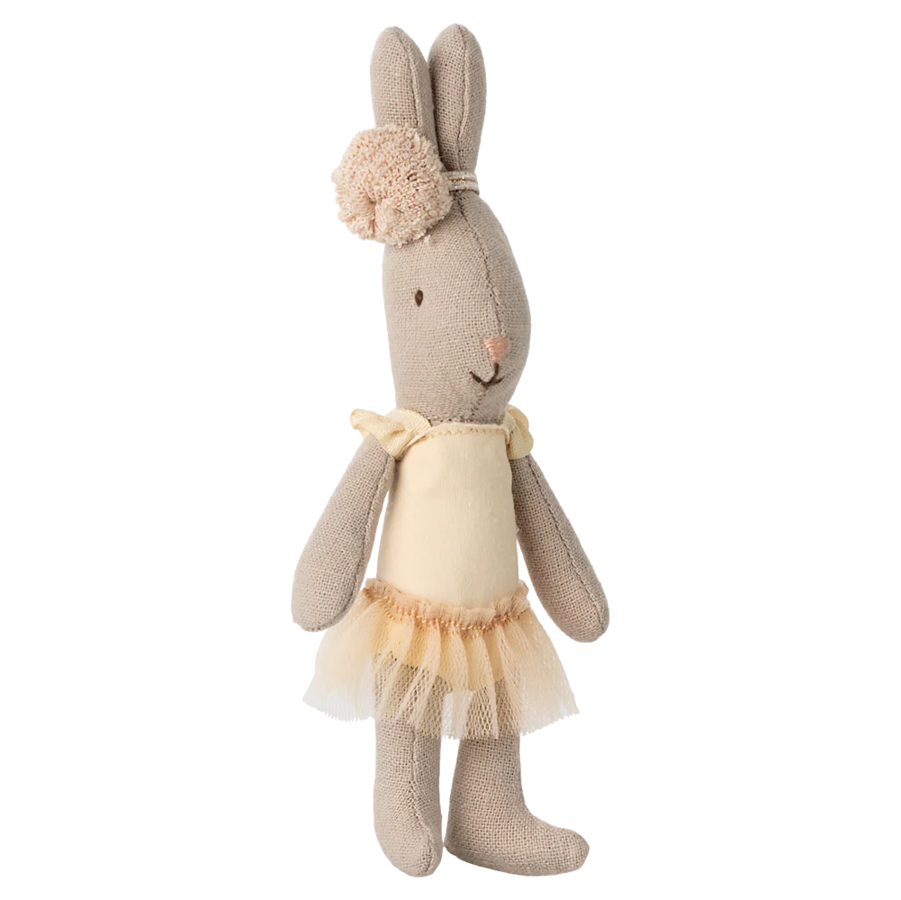 Stuffed bunny toy with a beige dress on a white background