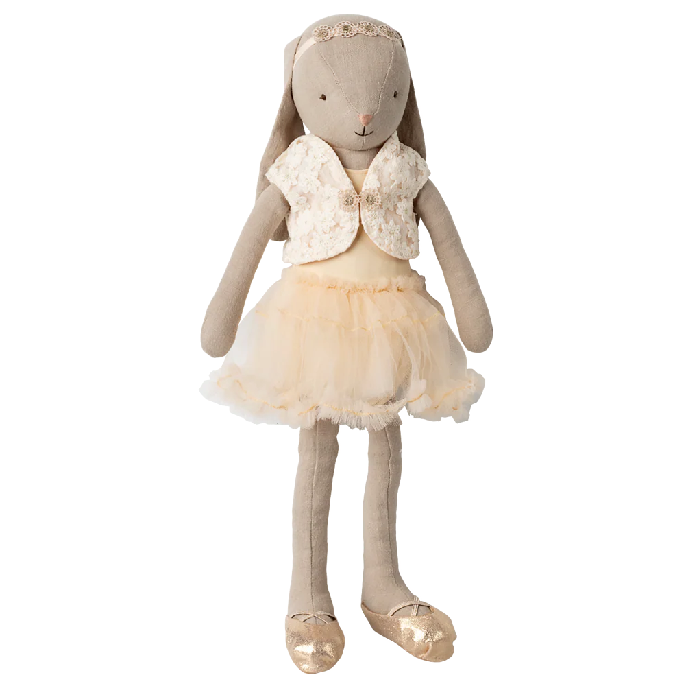 Stuffed rabbit toy dressed in a beige outfit with a vest and skirt on a white background