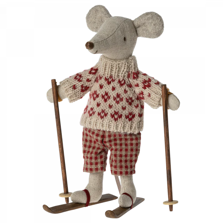 A toy mouse dressed in a red and white checkered ski outfit with ear warmers, holding ski poles, and standing on skis.