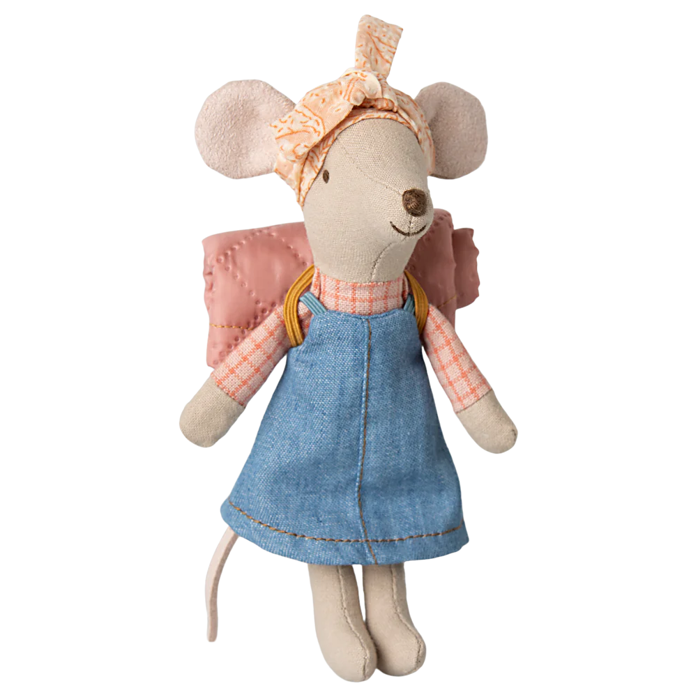 Stuffed toy mouse dressed in a blue dress and pink sleeping bag on a white background