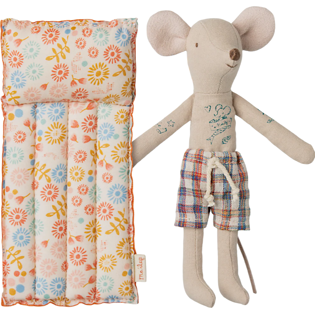 Stuffed mouse toy with plaid shorts next to a floral-patterned bag on a white background