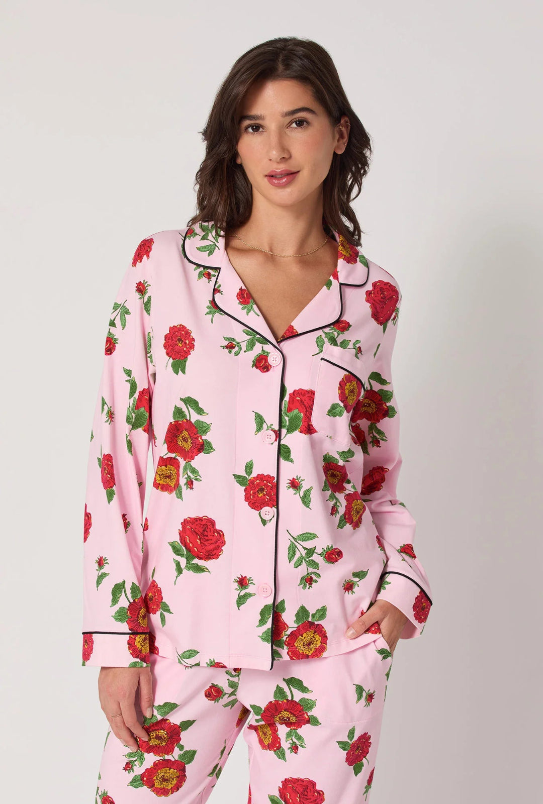 Woman wearing pink floral pajamas against a plain background