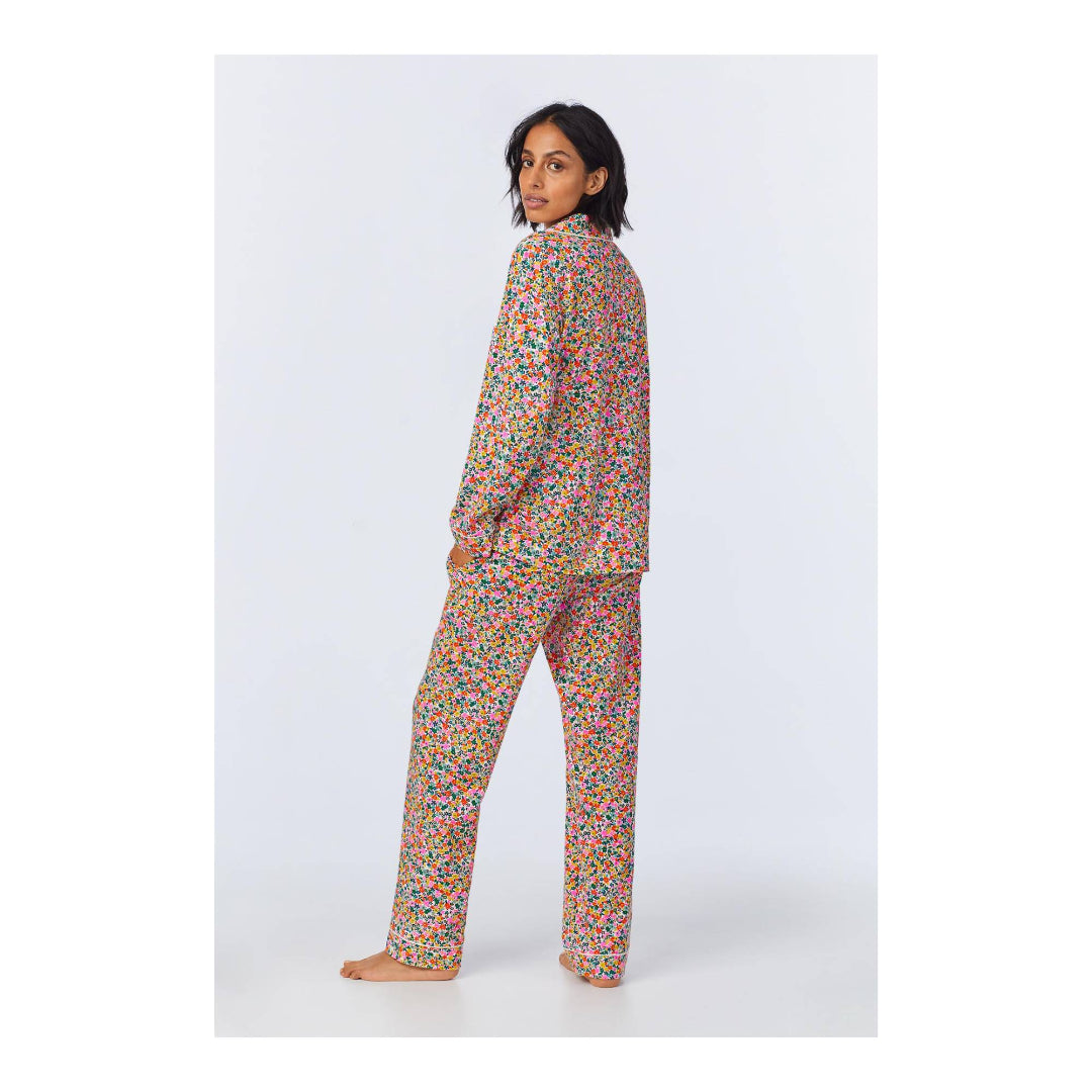 Person wearing a colorful floral pajama set on a white background