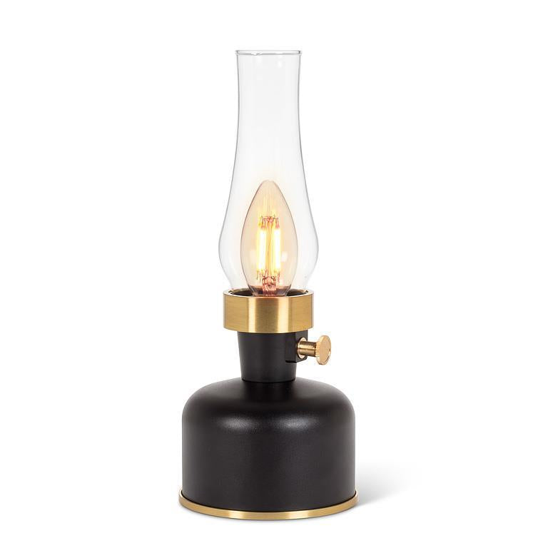 Black and gold lamp with a clear glass shade on a white background