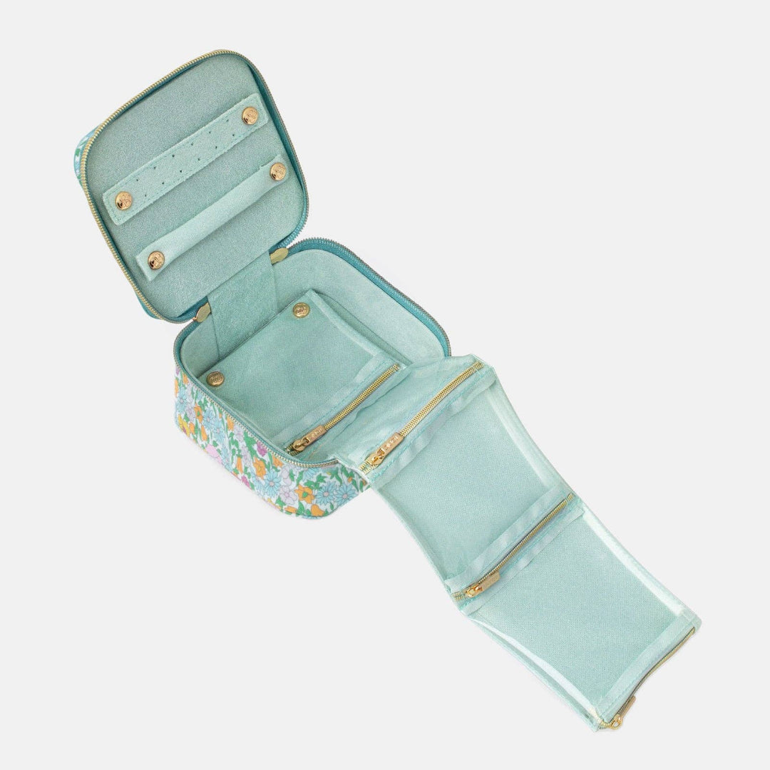Open teal travel case with floral pattern on a white background