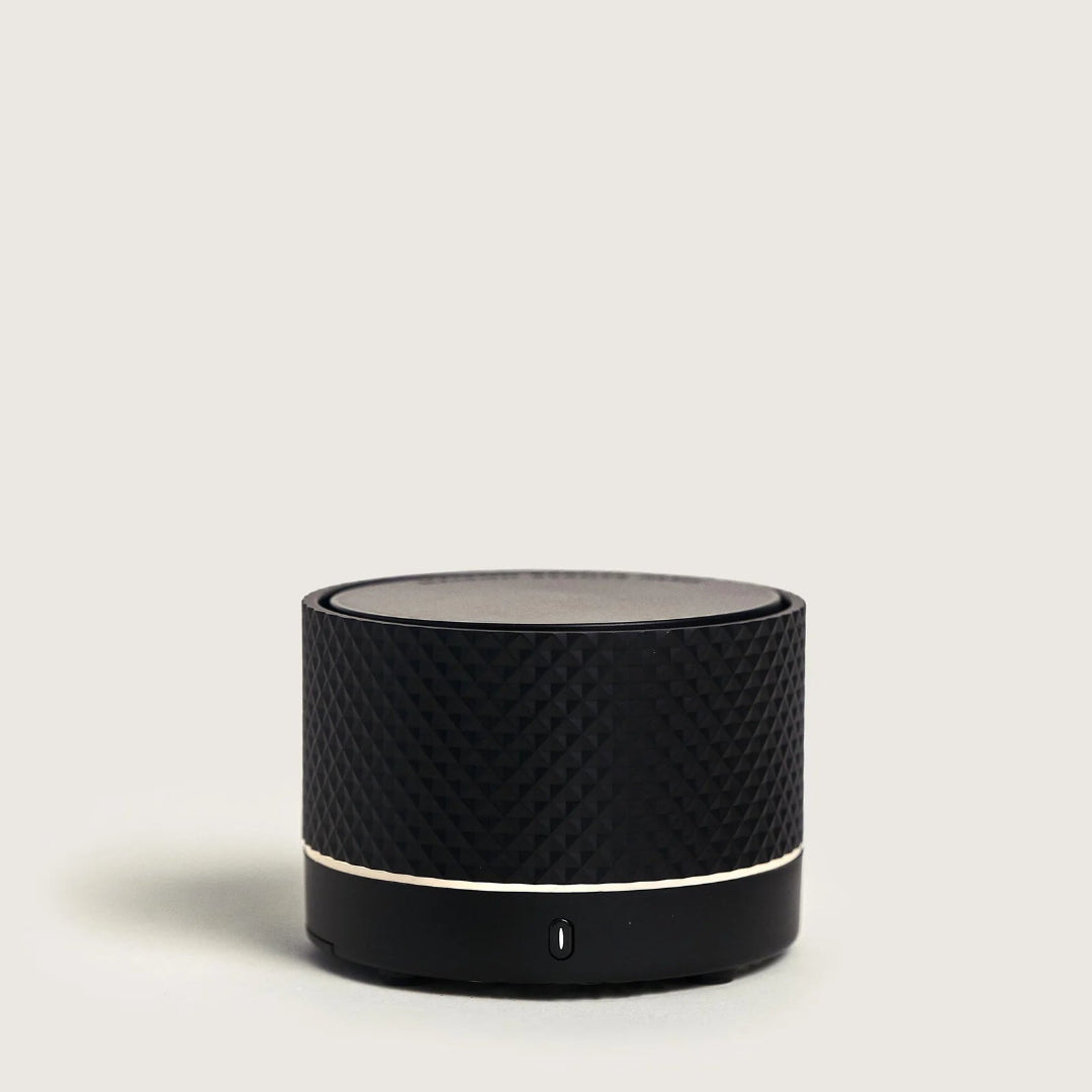 Black cylindrical portable diffuser on a light gray background