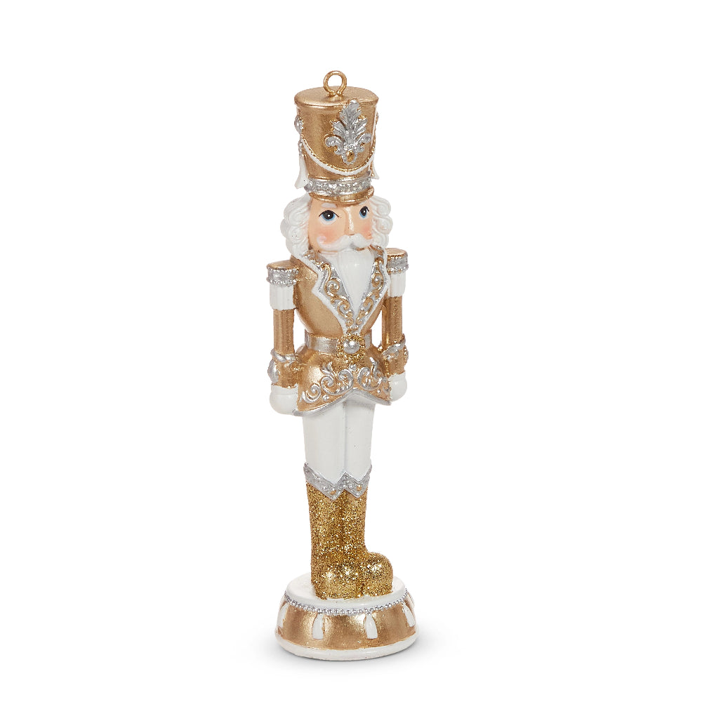 Decorative nutcracker figurine with gold and white attire on a white background