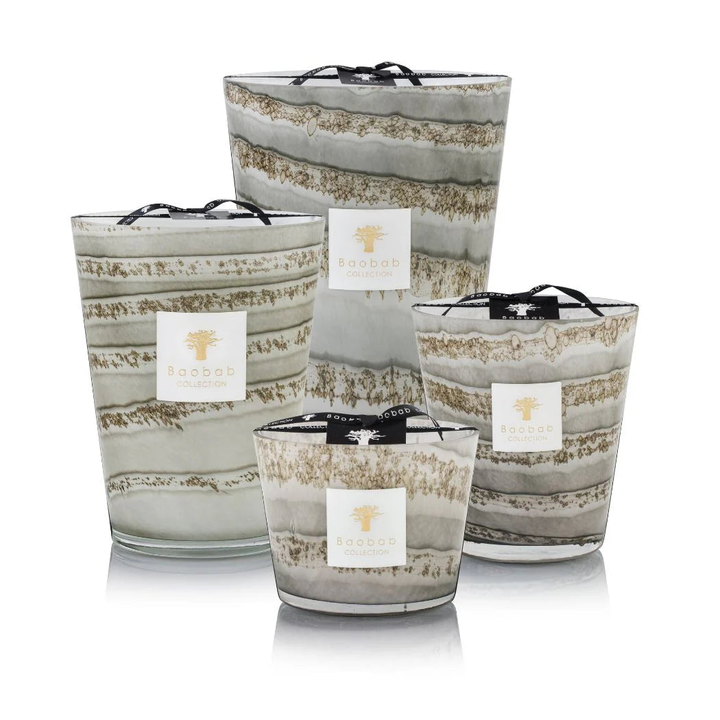 A set of hand-blown gray glass candles with various sizes, each holding a candle with a beige label.