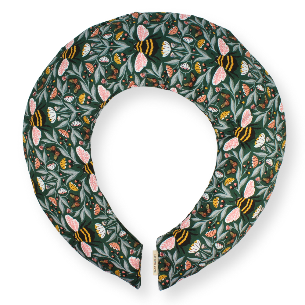 Neck pillow with floral and bee pattern on a white background