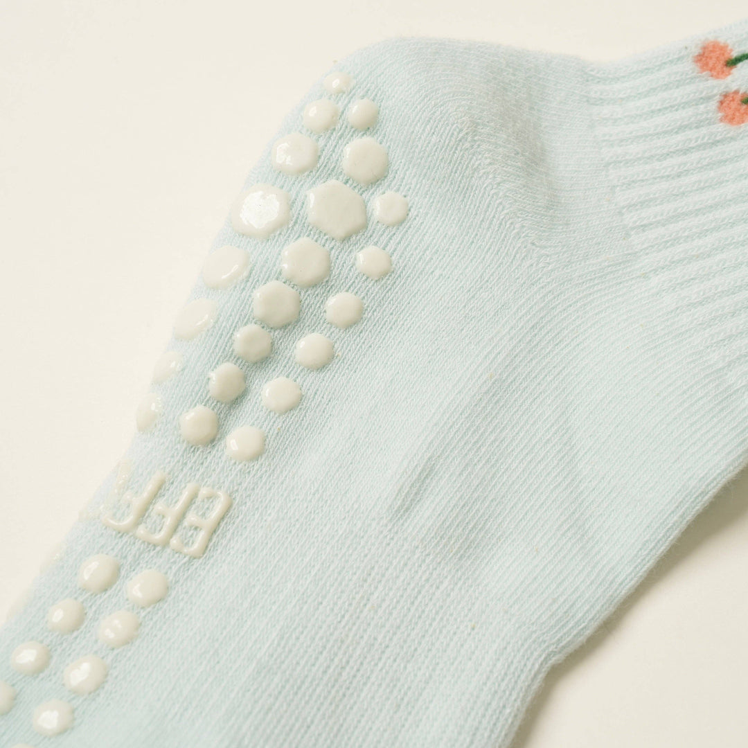 Light blue sock with textured sole on a beige background
