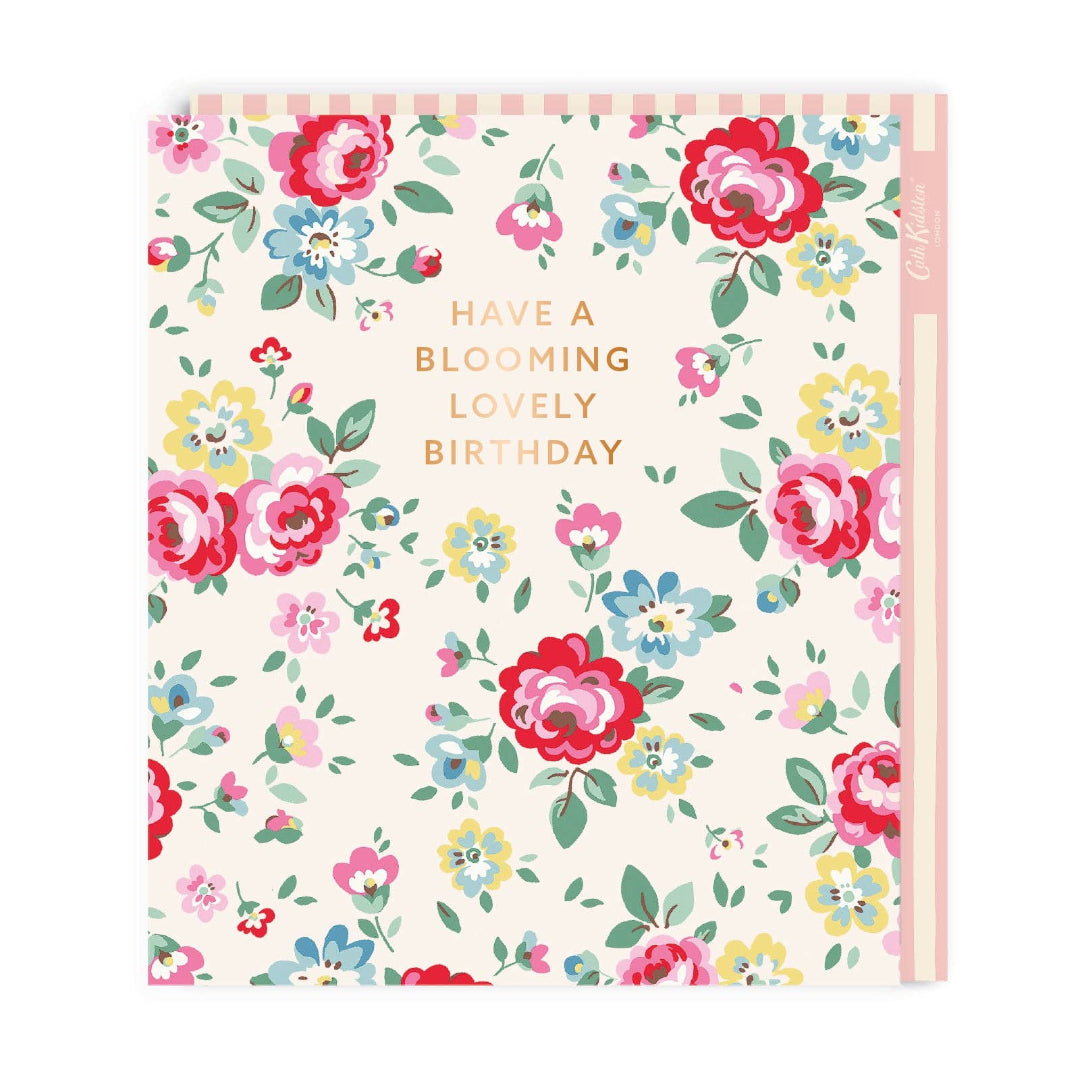 A floral birthday greeting card with the text 'HAVE A BLOOMING LOVELY BIRTHDAY' in a mix of capital and small letters.