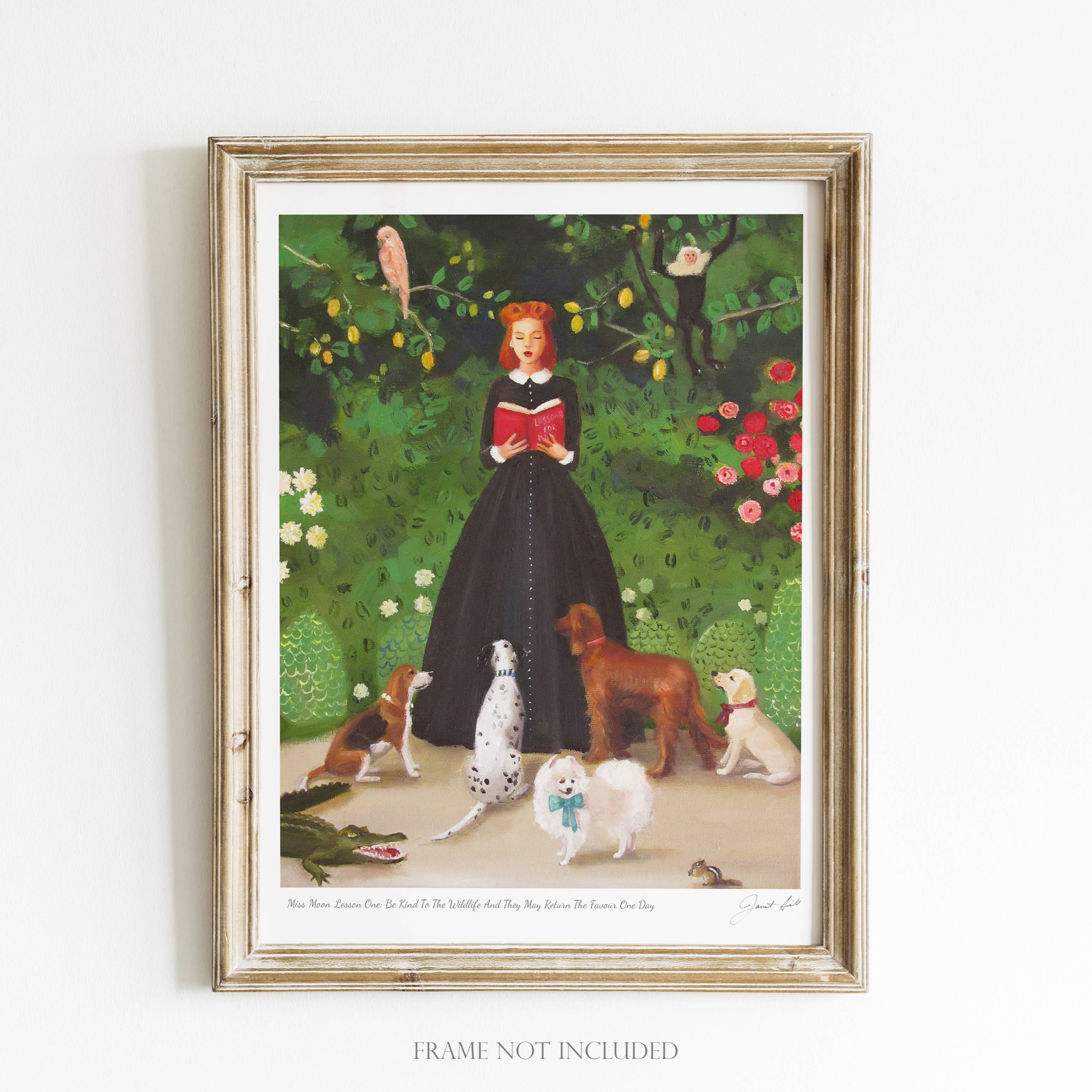 A framed art print featuring a whimsical scene with a woman reading to a child, surrounded by various dogs and a cat, with a garden and trees in the background. The frame is made of wood and the artwork is visible through the glass.