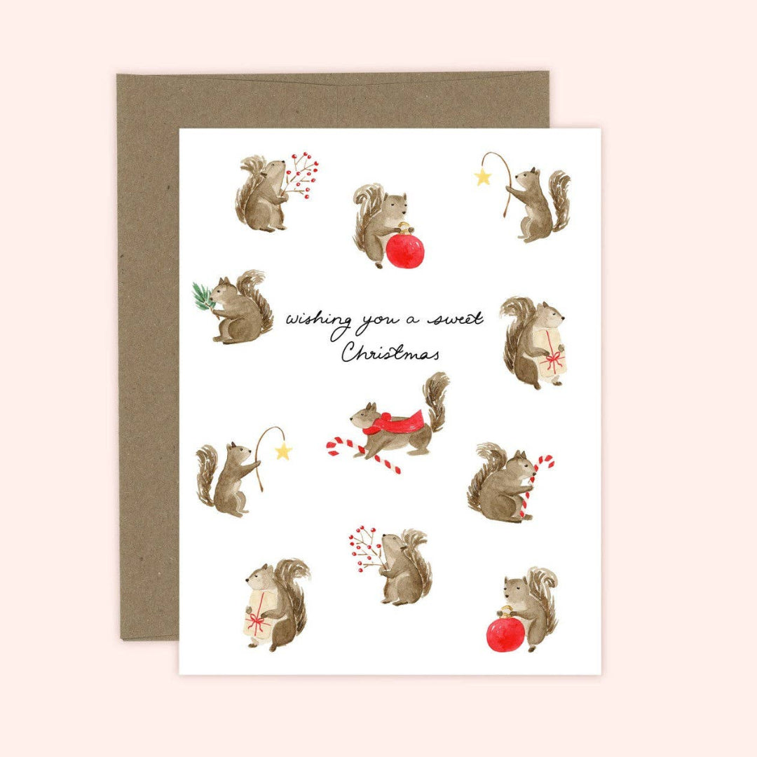 Greeting card with illustrations of squirrels and Christmas elements on a pink background