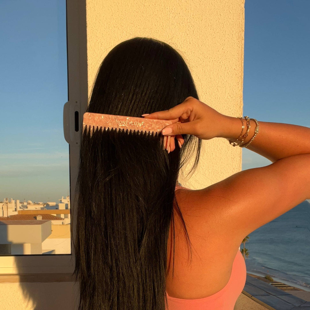 Person combing their hair with a scenic view in the background