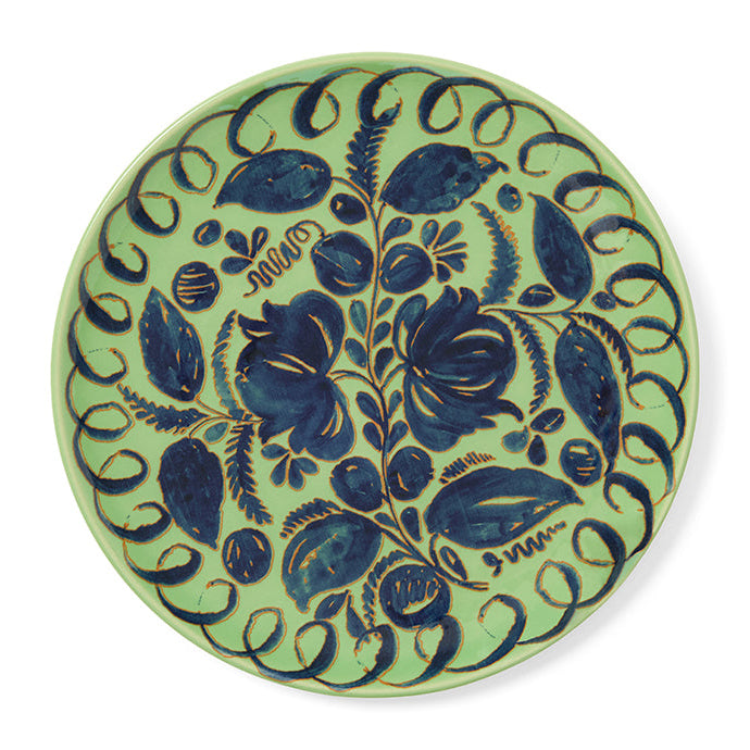Decorative green plate with blue floral pattern on a white background