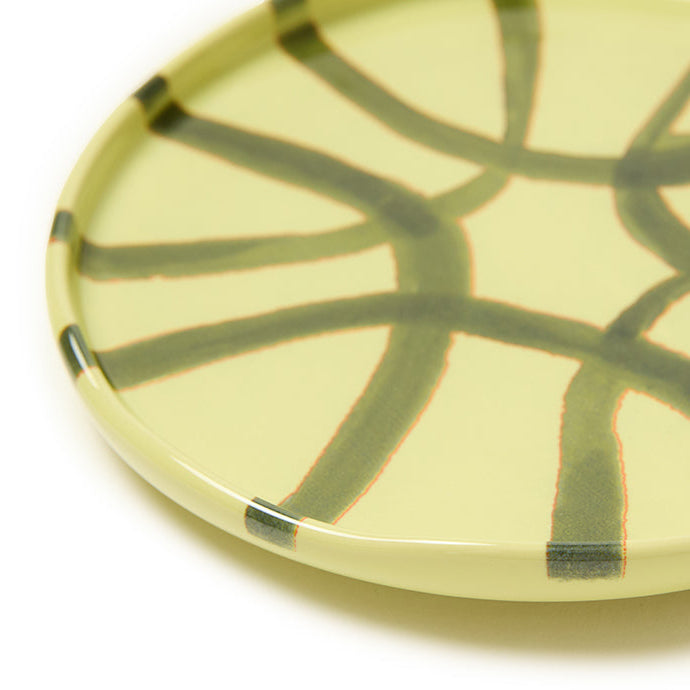 Ceramic plate with green abstract design on a white background