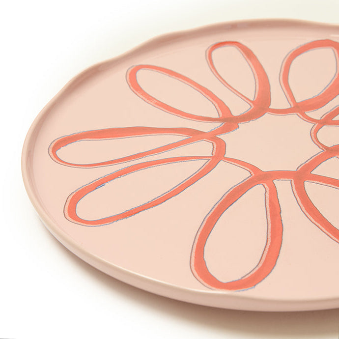 Pink ceramic plate with a floral design on a white background