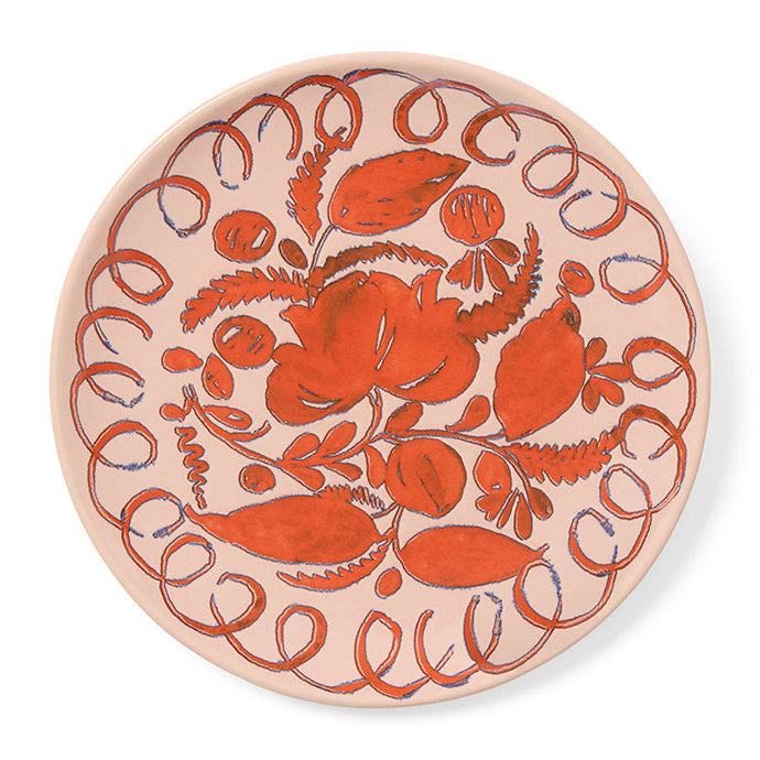 Pink decorative plate with red floral pattern on a white background