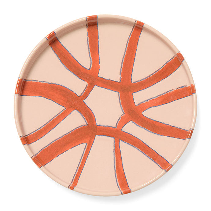 Ceramic plate with orange abstract design on a beige background