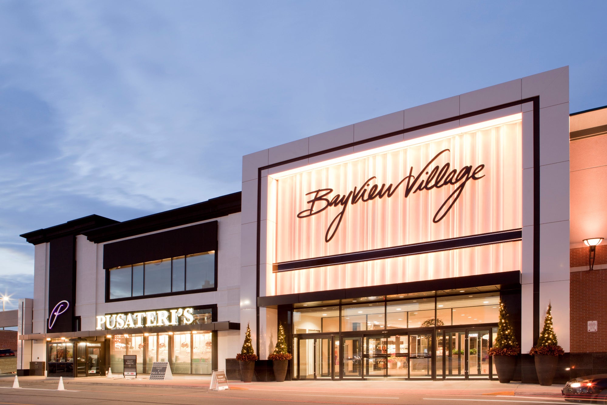 Commercial building with 'Bayview Village' and 'Pusateri's' signage at dusk.