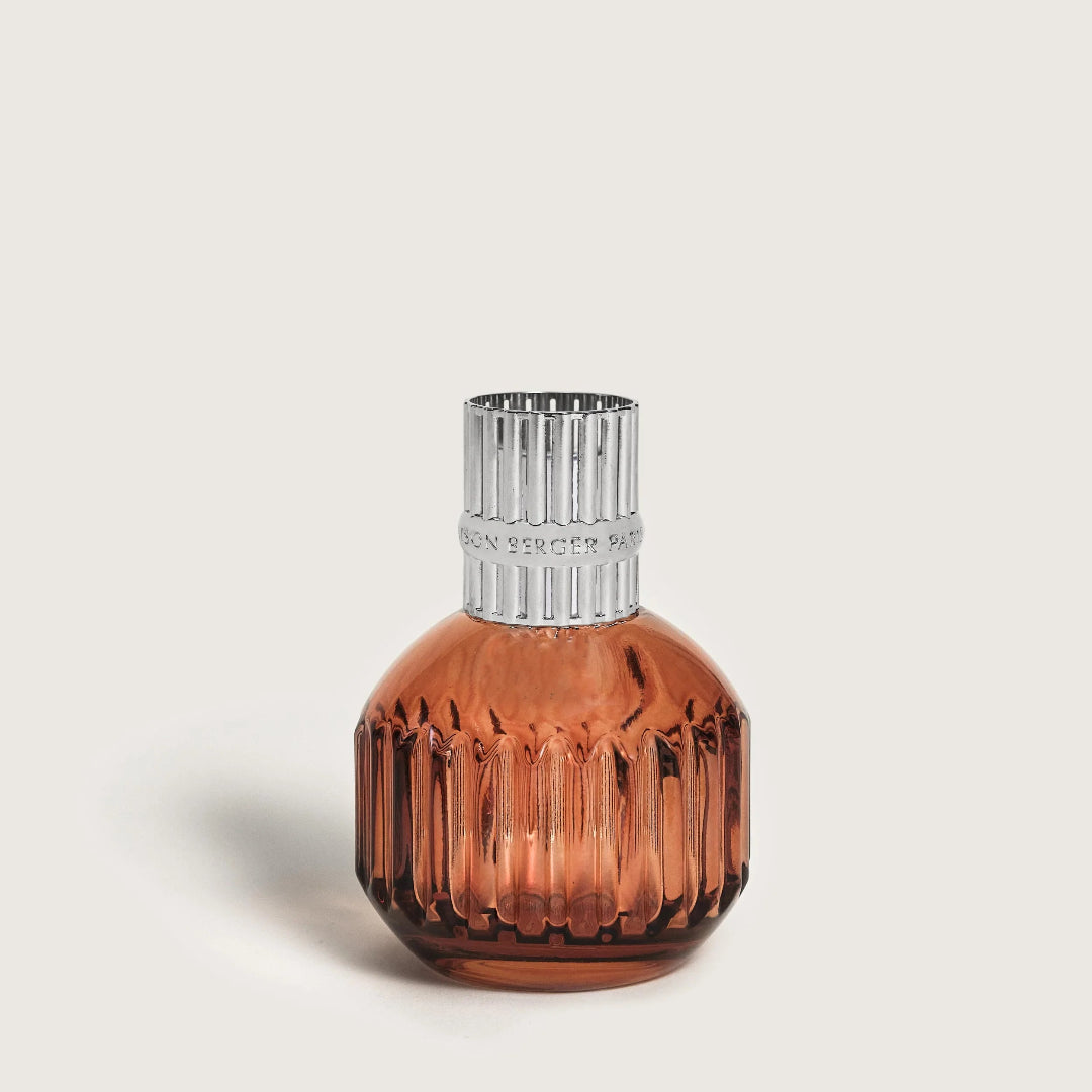 A small amber glass bottle with a ribbed, faceted design and a textured silver top.