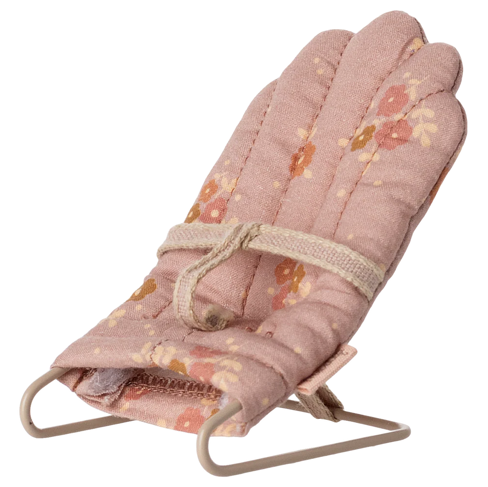 Floral patterned baby bouncer chair on a white background