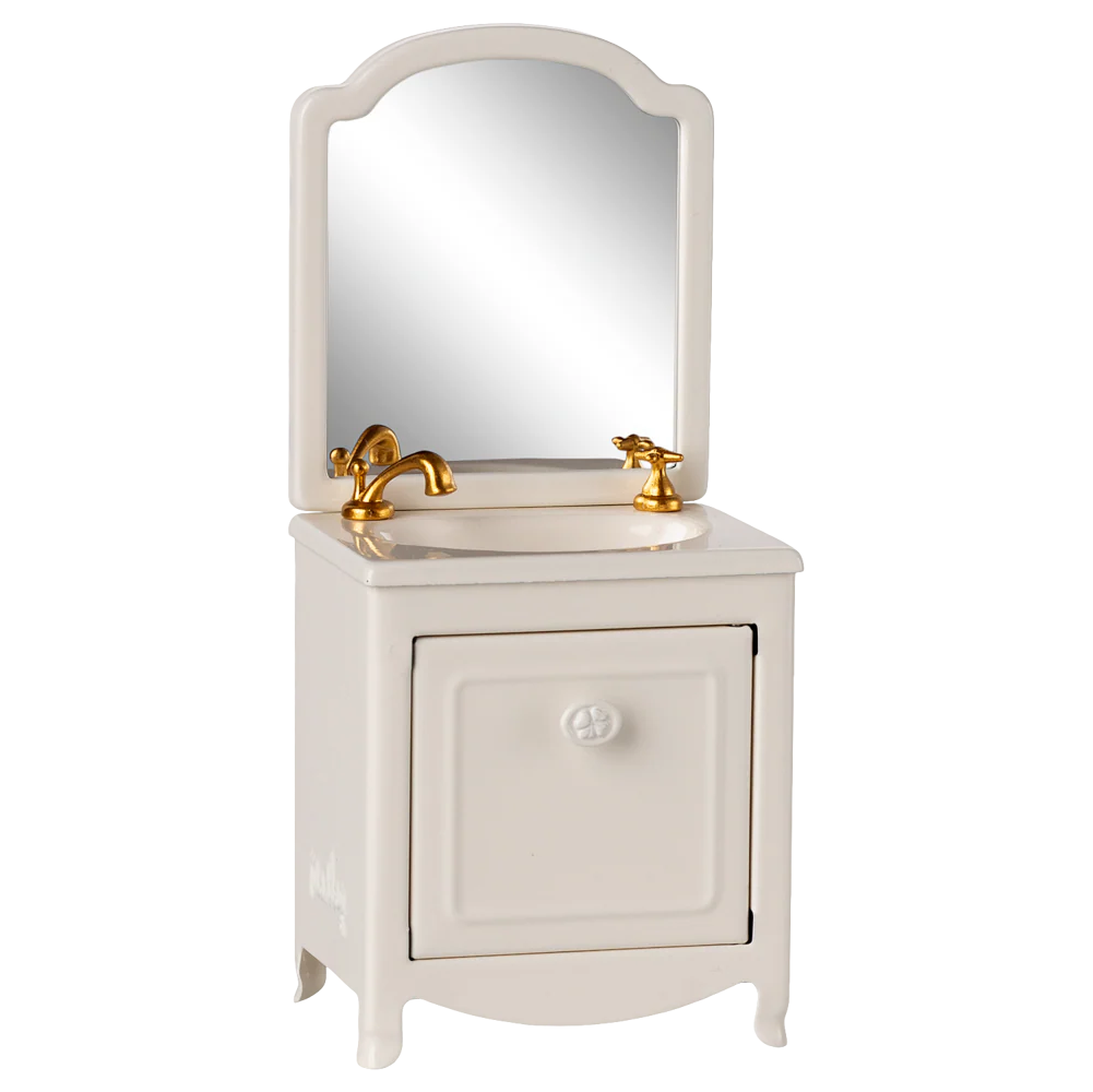 White vanity with mirror and gold fixtures on a white background