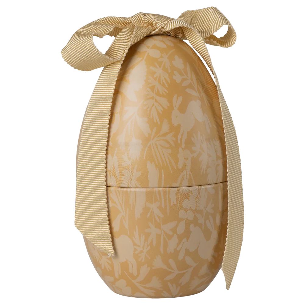 Decorative egg-shaped container with floral pattern and gold ribbon on a white background