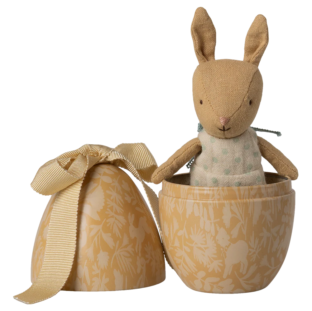 Stuffed rabbit toy in a decorative egg-shaped box with a ribbon on a white background
